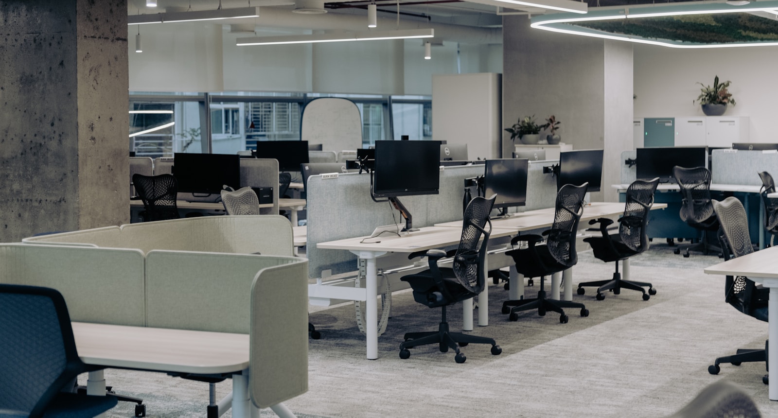 Rows of modern office workstations with chairs and monitors